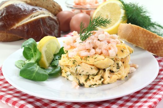 Scrambled eggs with shrimp, dill and corn salad on a plate