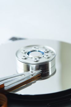 Close up (macro) of an exposed hard disk platter and read/write head.  Vertical (portrait) orientation with copy space above.