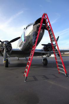 Two aircraft technicians inspecting the electronics on the nose of the DC3 aircraft in Troutdale airport Oregon.