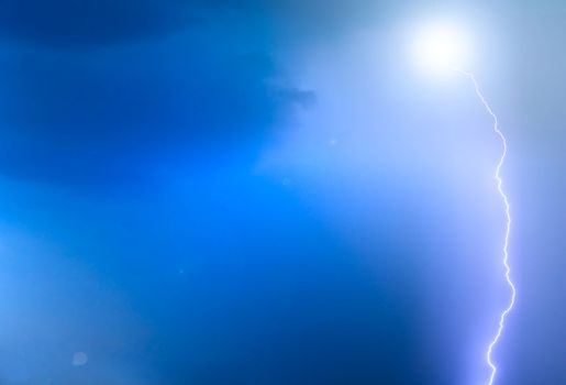 Deep blue sky background with lightning stroke and flare