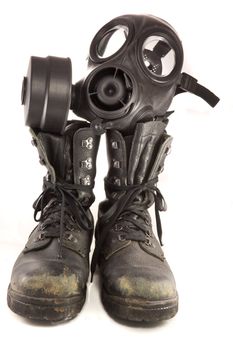 Picture of a couple of dirty old used millitary boots and a gasmask