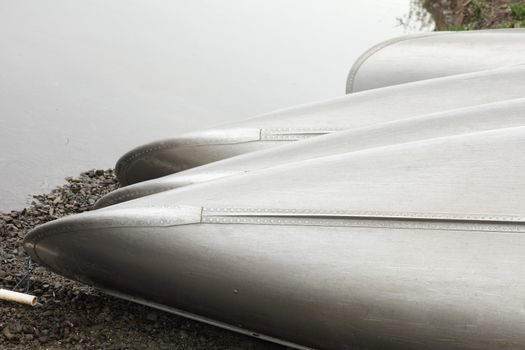 row of canoes by the shore of a lake