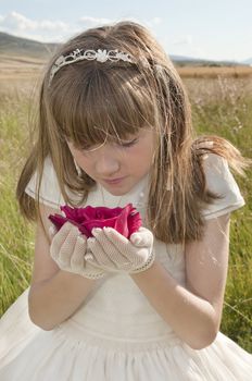 girl wearing first communion dress in the meadow