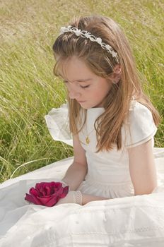 girl wearing first communion dress in the meadow