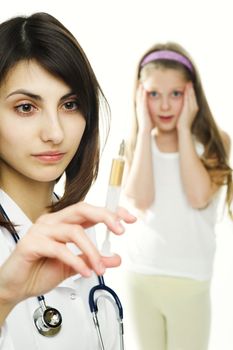 Doctor getting ready to make an injection to a young girl