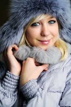 An image of a beautiful girl in grey fur hat