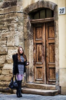 Stock photo: an image of a nice woman standing at old door