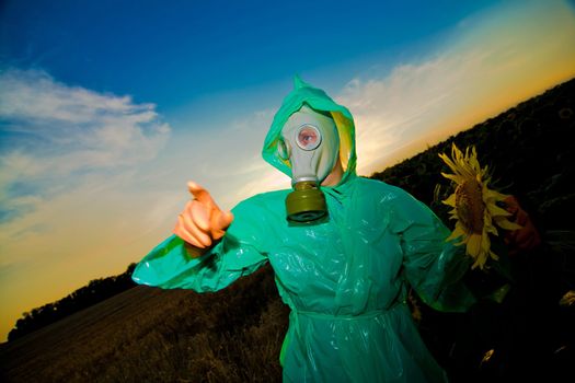 An image of man in a respirator on sunflower field