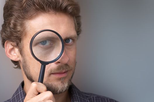A portrait of a young man with a magnifying glass