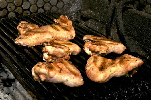 chicken wings are fried on the grill