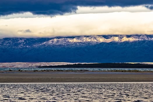 Sea water, sand, mountain and clouds layers of Velebit, Croatia