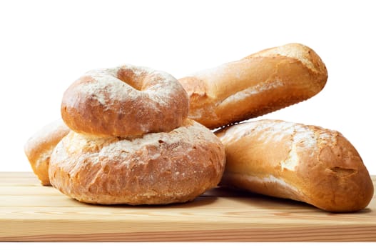 A selection of bread loaves on a wooden board against a pure white background.