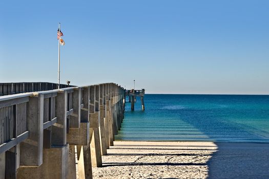 A long fishing pier into the ocean, a popular tourist area in Panama Beach, Florida.