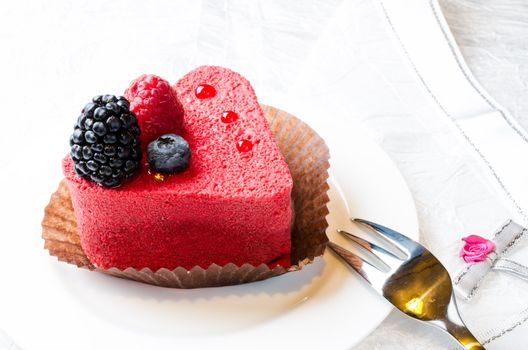 Red heart shaped cake with berries