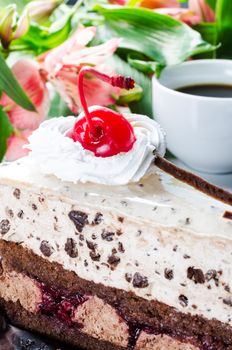 Close up cake with cherry and flowers on background and cup coffee