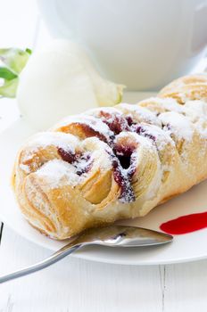 Pastry with cup and flower on background