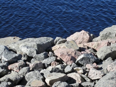 Some granite looking rocks and blue water