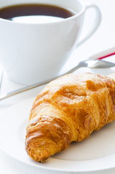 Croissant with coffeee on a background