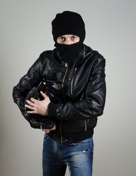 Portrait of male burglar with a handbag.