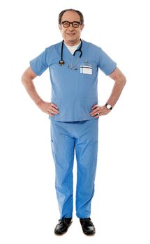 Full length view of smiling experienced medical professional posing hands are on his waist