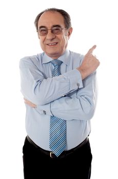 Welldressed senior businessperson pointing away with crossed arms