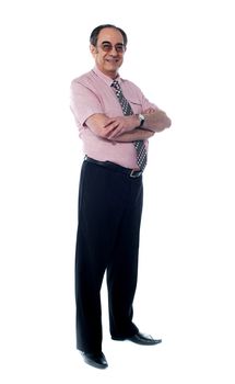 Senior business associate smiling as he poses with folded arms against white background