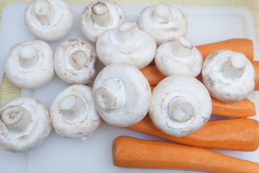 Carrots and mushrooms on the counter ready for cutting