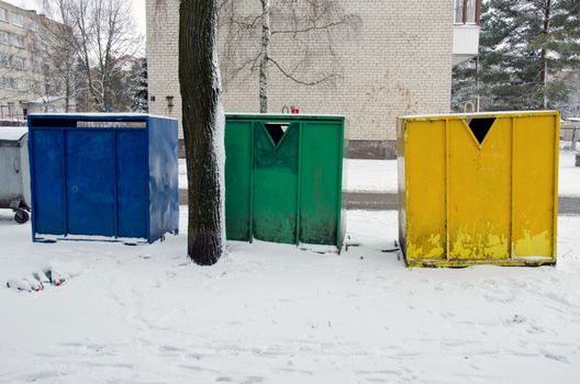 waste sorting in multistore residential houses district. colorful metal garbage containers area in city.