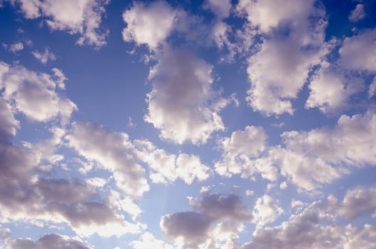 beautiful cloudy blue spring sky sun-lit background.