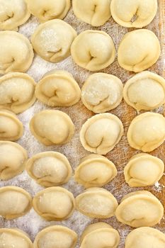 Meat dumplings on the kitchen board. Dumplings or ravioli is a traditional East Slavic kitchen dish also known as pelmeni.