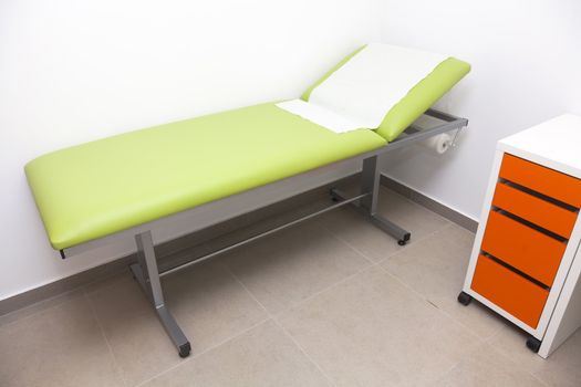 Patient examination room with a bed and wheeled racks