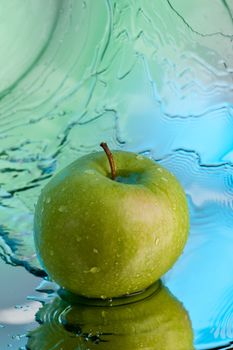 ripe green apple over abstarct blue background