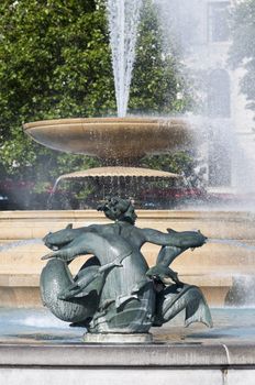 Detail of statue by water fountain in Trafalgar Square, central London, UK