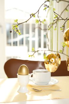 Sunny easter morning. Gold decorated Easter egg