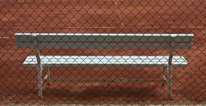 empty tennis court  and white wooden seat