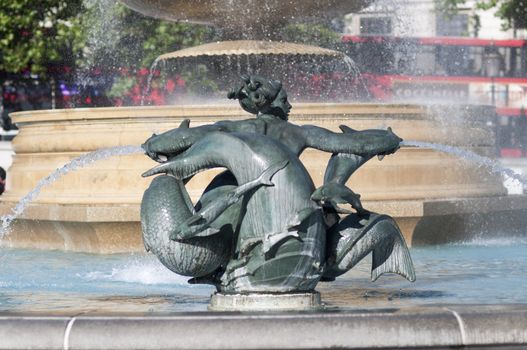 Detail of statue by water fountain in Trafalgar Square, central London, UK