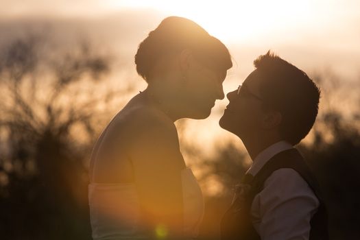 Bright sunset behind intimate lesbian couple outdoors