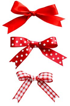 Three types of isolated red ribbon bows on white background.  One plain, two patterned with polka dots and checks.
