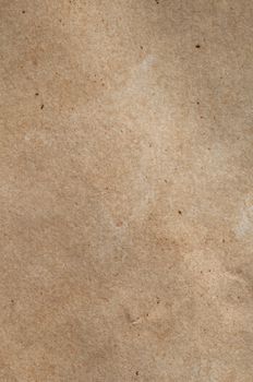 A piece of mid-toned fibrous, textured brown paper with scratches, fibres and flecks visible.