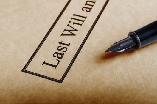 Close up of the bordered title of a last Will and Testament set on parchment paper with nib of fountain pen to the right.