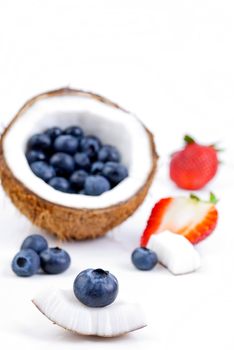 healthy fresh fruits - strawberry, blueberry and coconut isolated on white background