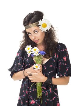 Young girl dressed like hippie with bunch of flowers posing to the camera
