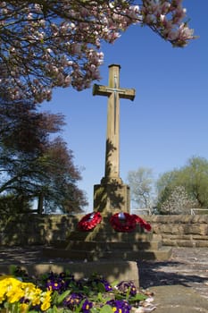 A village cross surrounded by poppies in memory of those who fought in the war