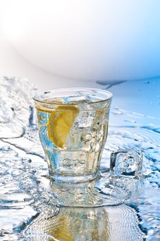 cold soda drink with ice and lemon slashed by water