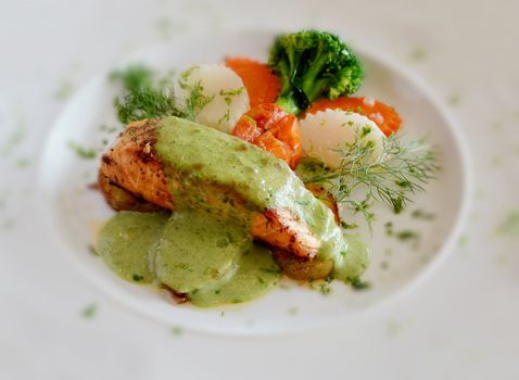 fish steak with green sauce on white dish