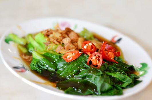 kale fried with oyster sauce  , topped with fried onion and red chili 