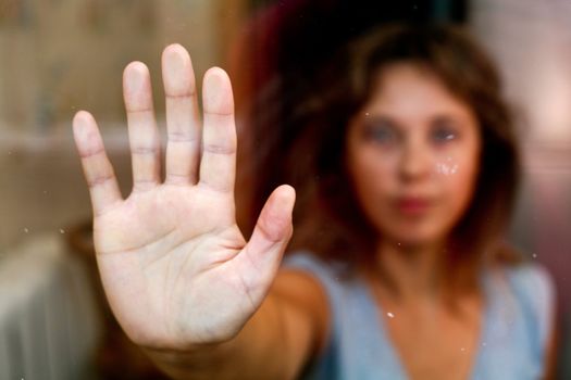 Nice woman stands outside the window.