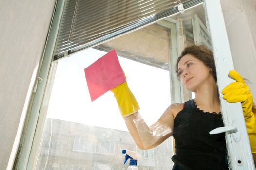 An image of a woman cleaning the window