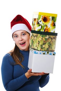 A surprised girl in a christmas cap with three gift boxes