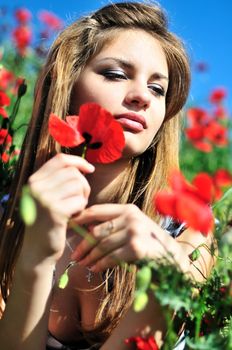 beautiful girl with long hair relaxing in the  poppy field